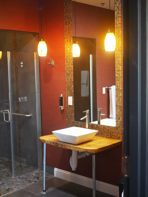 modern looking burgundy, gold, and grey bathroom with glass shower doors