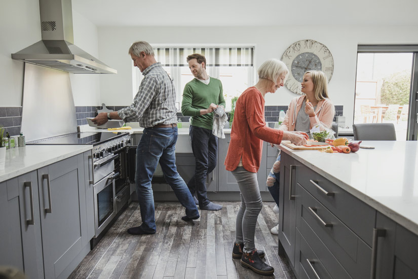 Caucasian family with grown kids making lunch in lovely modern grey kitchen - your recovery