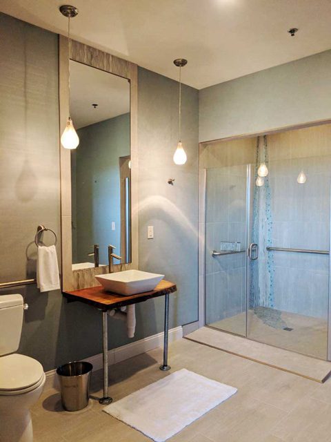 modern decor bathroom with glass shower doors and pendant lights