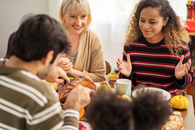 family enjoying thanksgiving meal together - thanksgiving