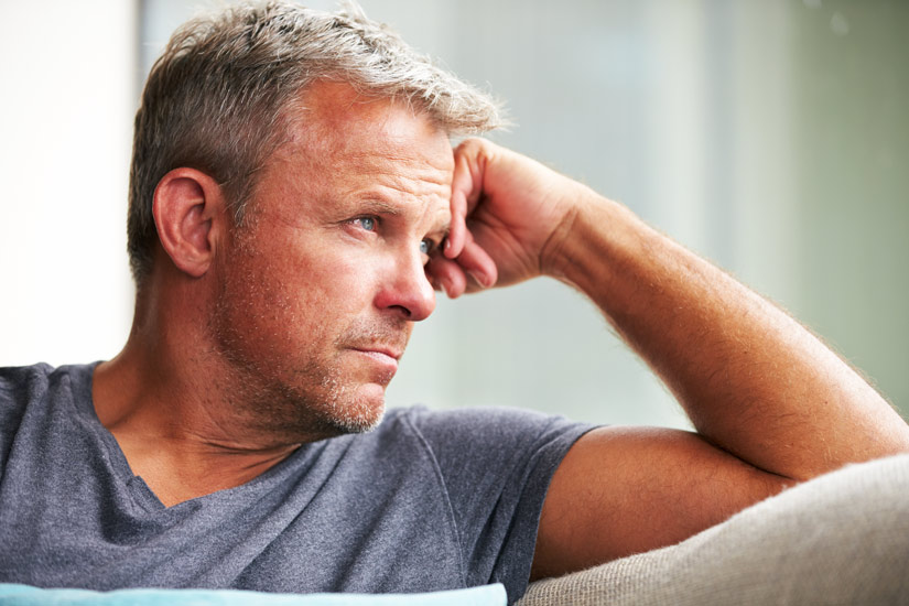 handsome middle age man sitting at home thinking - caring