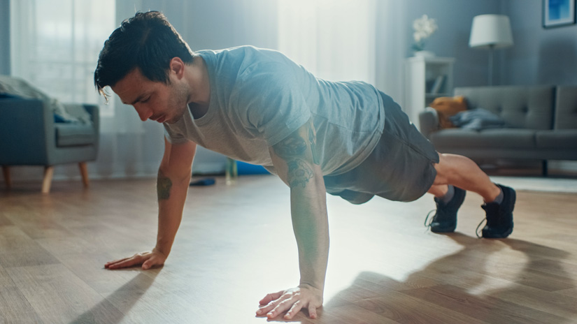 dark haired man doing push ups at home - exercise