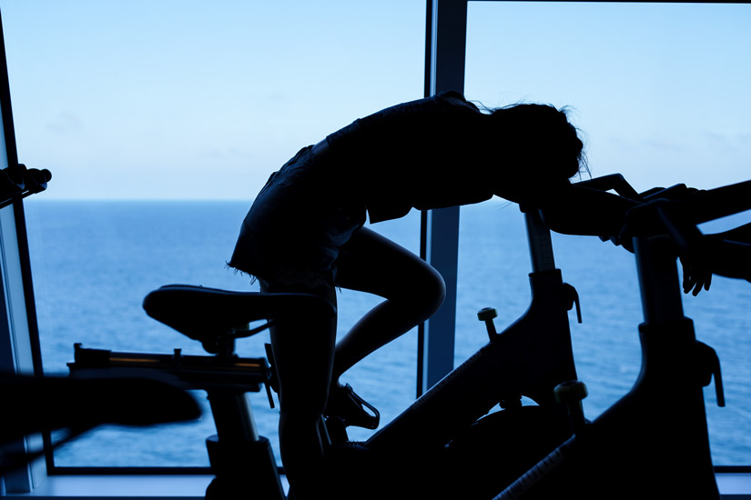 silhouette of exhausted woman on stationary bike - substitute addictions