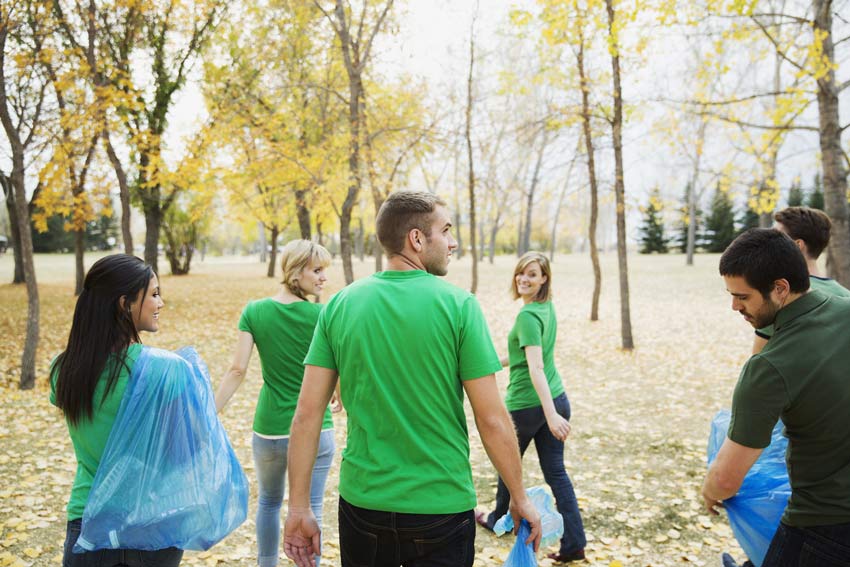 group of young adults cleaning up trash in a park - guilt